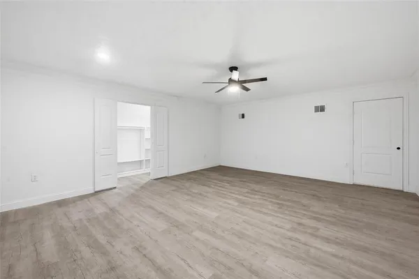 an empty room with an entryway and fan