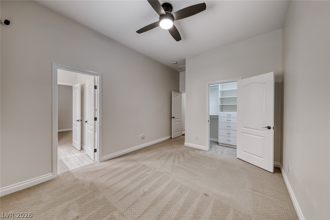 2122 Mooreview Street Henderson, NV 89012 - Photo 26 of 44 A quiet bedroom featuring vaulted ceilings, a ceiling fan, and an organized walk-in closet.