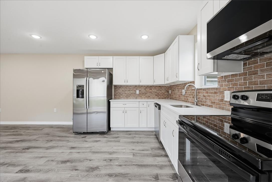 5641 North Coplay Road Whitehall, PA 18052 - Photo 6 of 68 A contemporary kitchen features bright white cabinetry and gleaming stainless steel appliances.