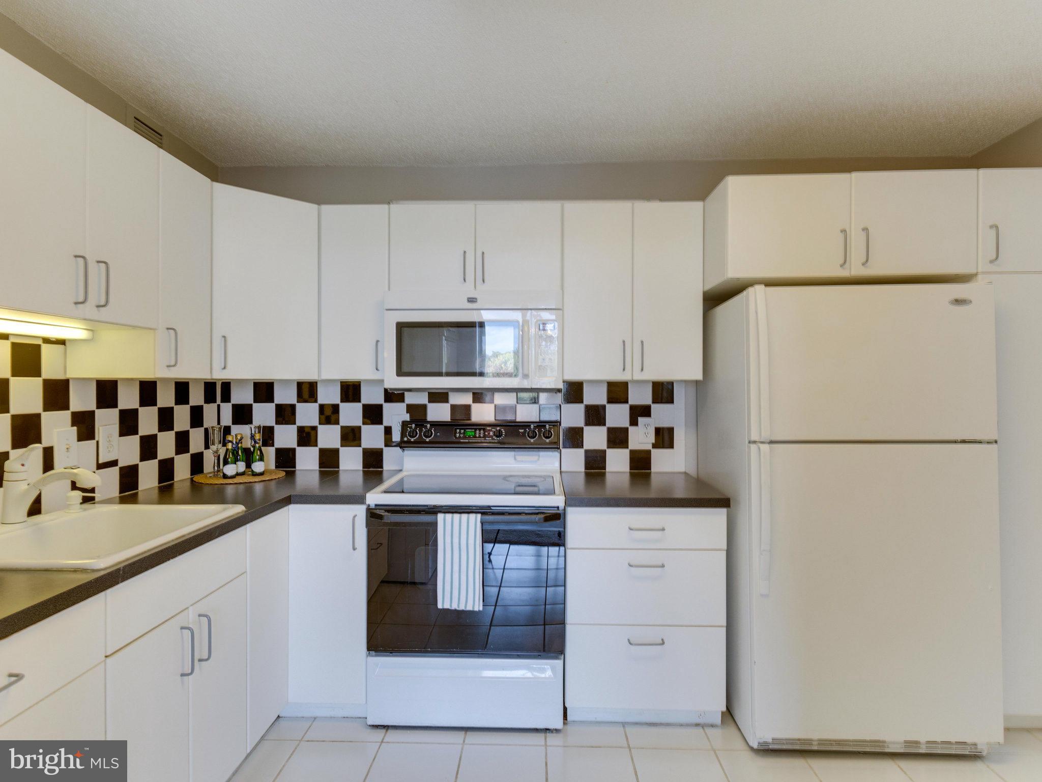 6800 Fleetwood Road, Unit 711 McLean, VA 22101 - Photo 5 of 27 a kitchen with white cabinets and refrigerator