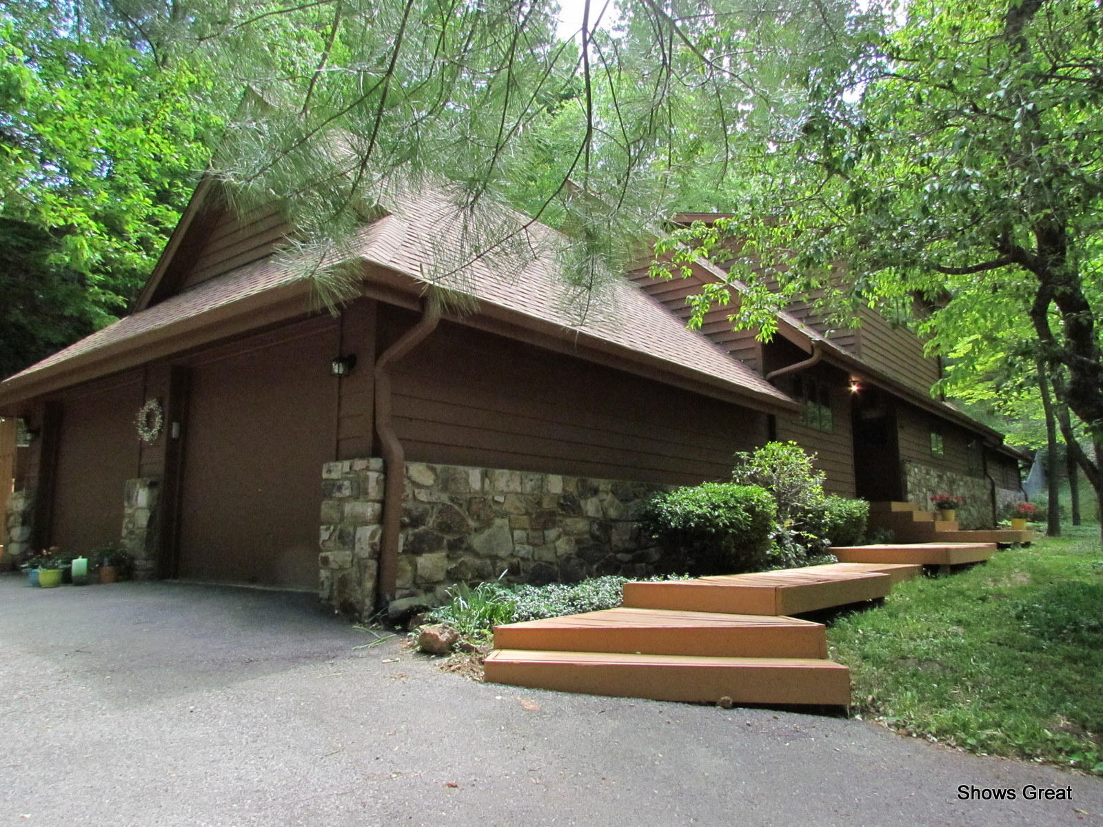 a backyard of a house with wooden fence and large trees