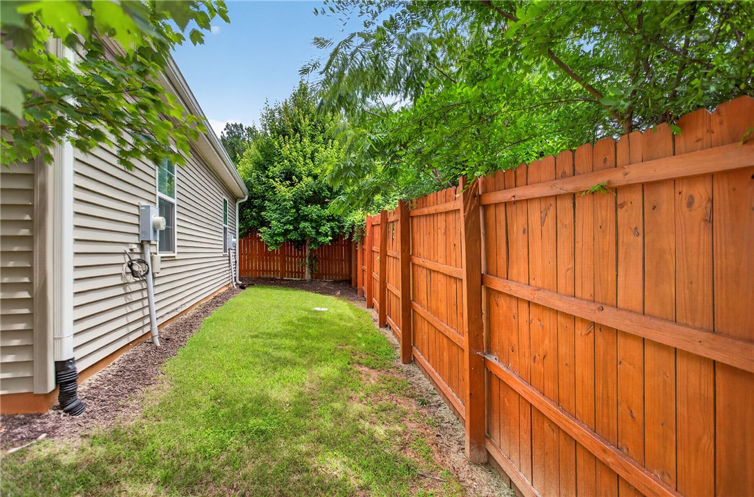 235 Pendleton Road, Unit K1 Clemson, SC 29631 - Photo 9 of 49 A private, grassy yard bordered by a sturdy wooden fence, offering a tranquil outdoor retreat.