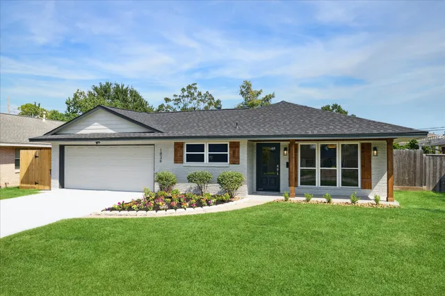 a front view of a house with a garden and yard