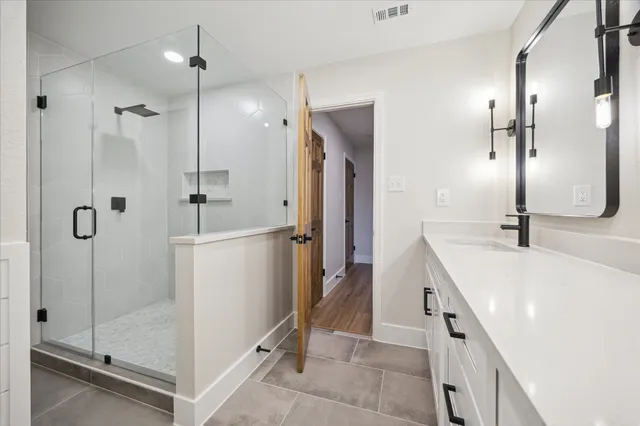 a bathroom with a sink a mirror and a shower