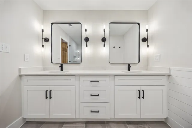 a bathroom with double vanity sinks and a mirror