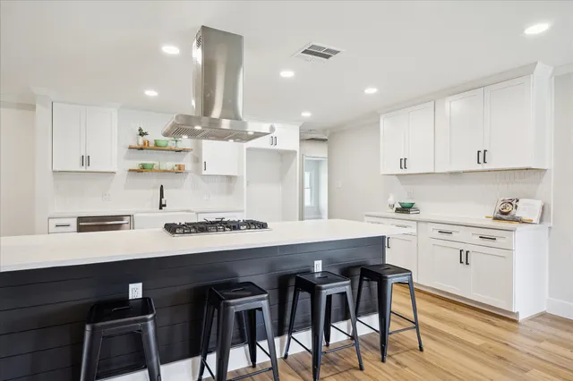 a kitchen with kitchen island cabinets and chairs in it