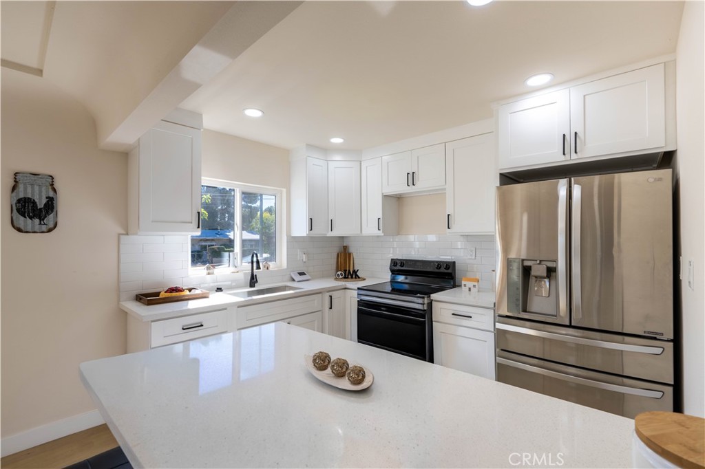 911 West George Street Banning, CA 92220 - Photo 14 of 32 a kitchen with granite countertop stainless steel appliances a sink a stove and refrigerator