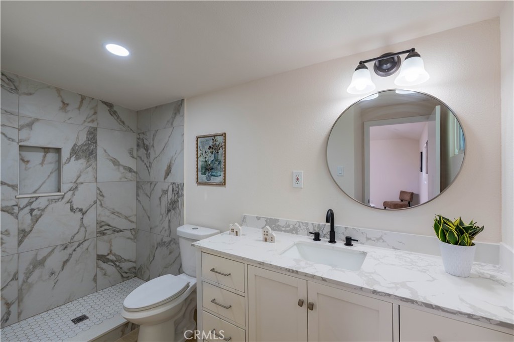 911 West George Street Banning, CA 92220 - Photo 19 of 32 a bathroom with a granite countertop toilet a sink and mirror