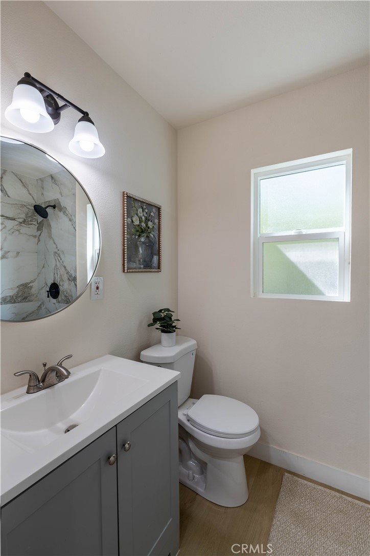 911 West George Street Banning, CA 92220 - Photo 25 of 32 a bathroom with a toilet a sink and mirror