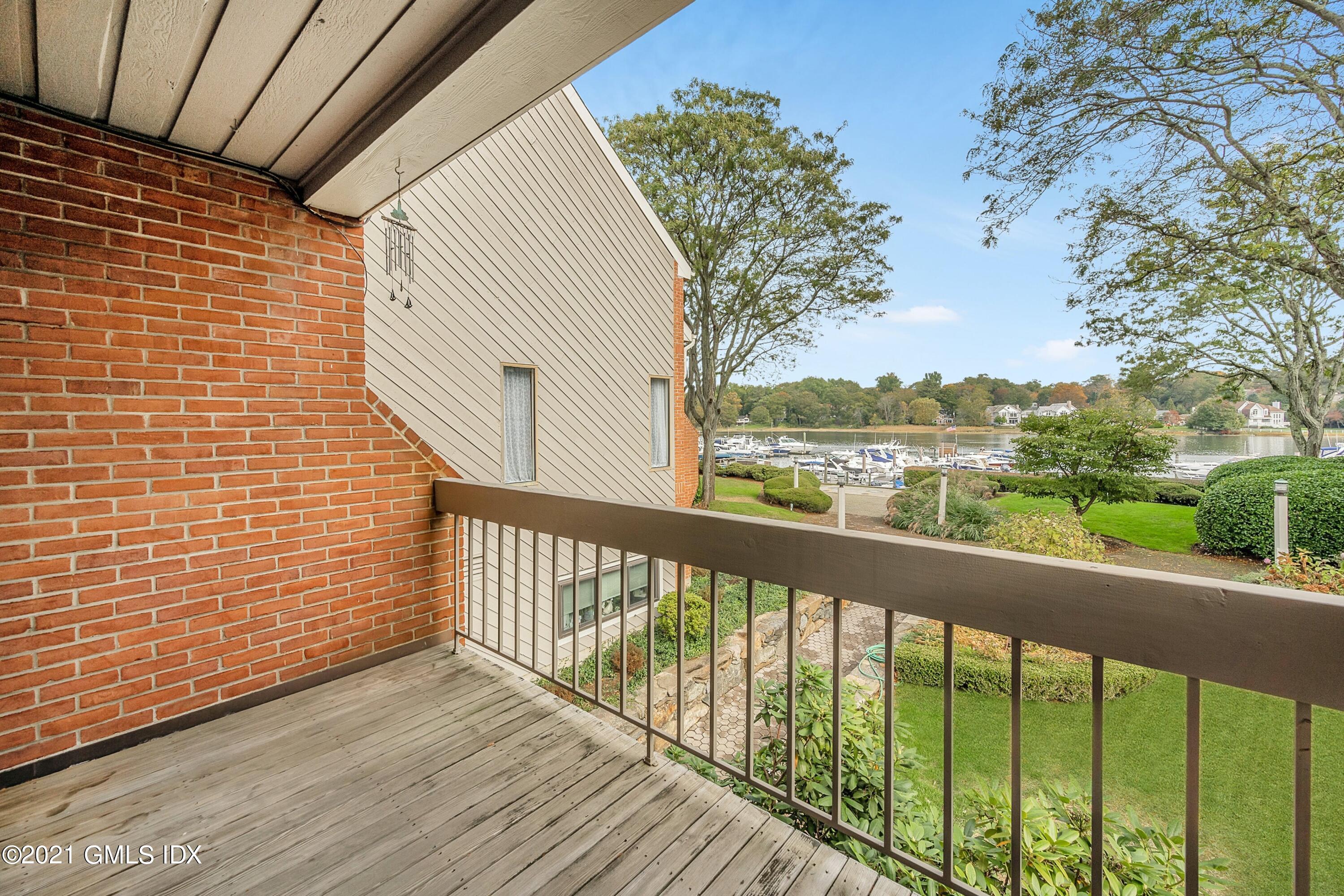 7 River Road, Unit 303 Cos Cob, CT 06807 - Photo 17 of 20 a view of a balcony with wooden floor and fence