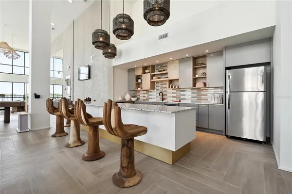 a kitchen with a refrigerator a stove top oven a clock and a window