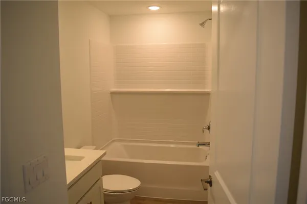 a bathroom with a granite countertop toilet and a shower