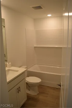 a bathroom with a granite countertop toilet a sink and a mirror