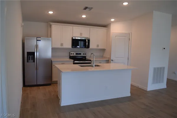 a kitchen with stainless steel appliances a refrigerator a stove a microwave and a sink