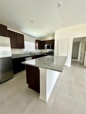 a large kitchen with stainless steel appliances granite countertop a sink and cabinets