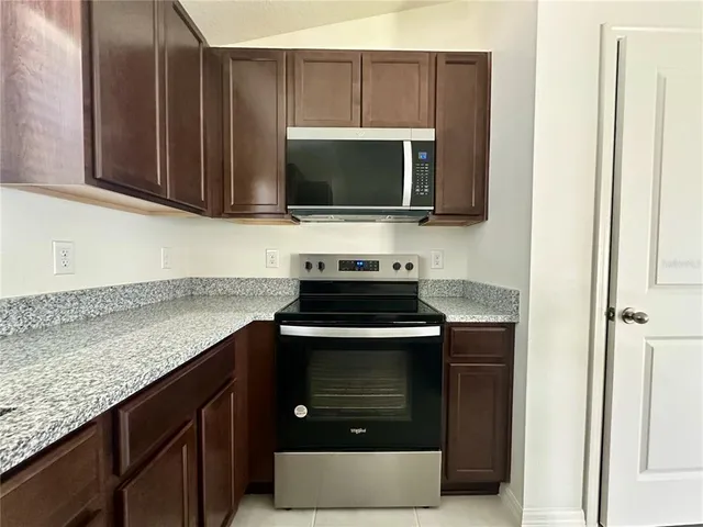 a kitchen with stainless steel appliances granite countertop a stove microwave and oven