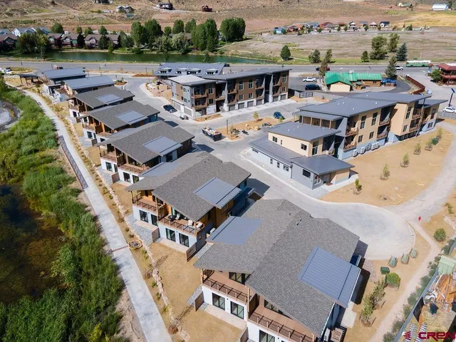 an aerial view of a house with a yard garage and lake view