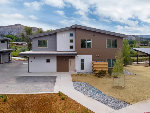 a view of a house with backyard and sitting area