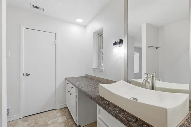 a bathroom with a granite countertop sink and a mirror
