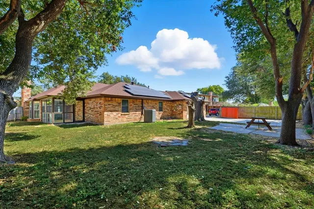 a view of a yard in front of a house with large trees