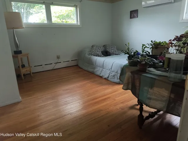 a bedroom with a bed a window and dresser
