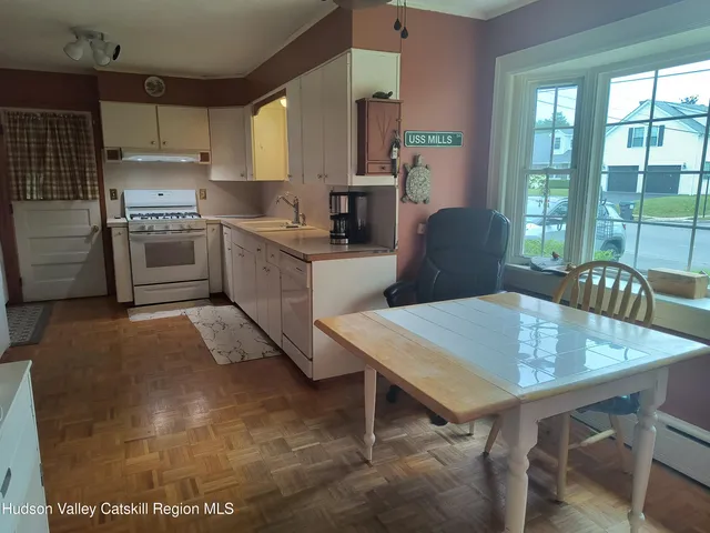 a kitchen with a table chairs microwave and cabinets
