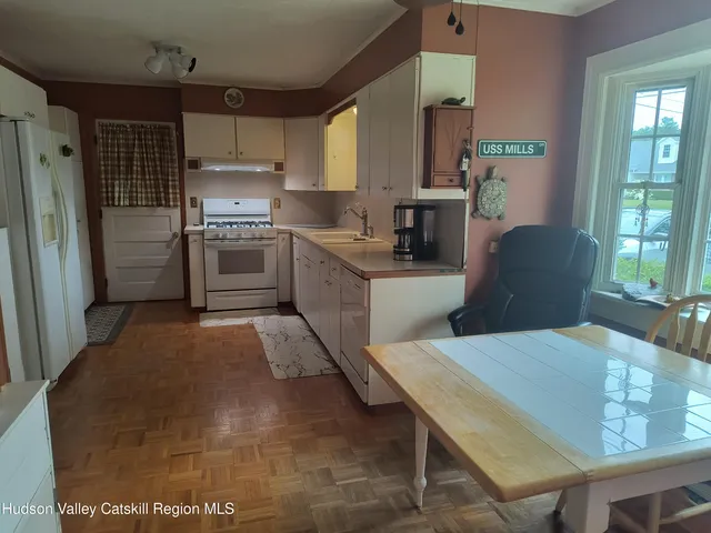 a kitchen with stainless steel appliances kitchen island granite countertop a refrigerator and a sink