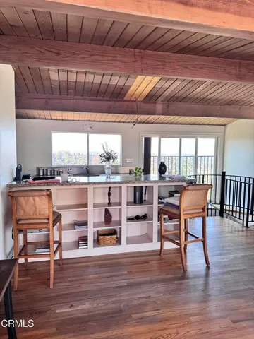 a room with lots of wooden furniture and windows