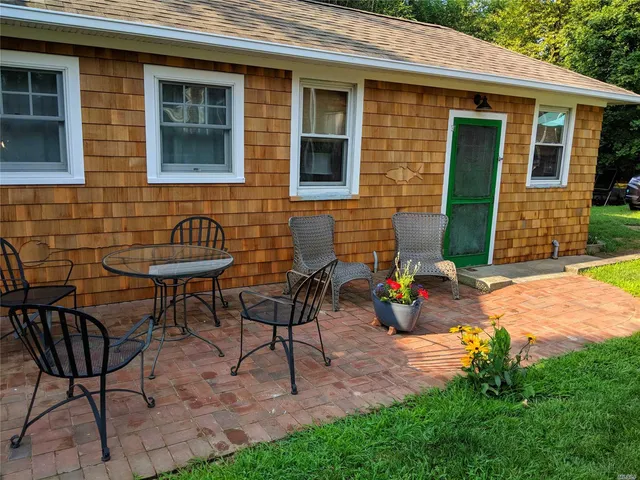 a view of a chairs and table in backyard of the house