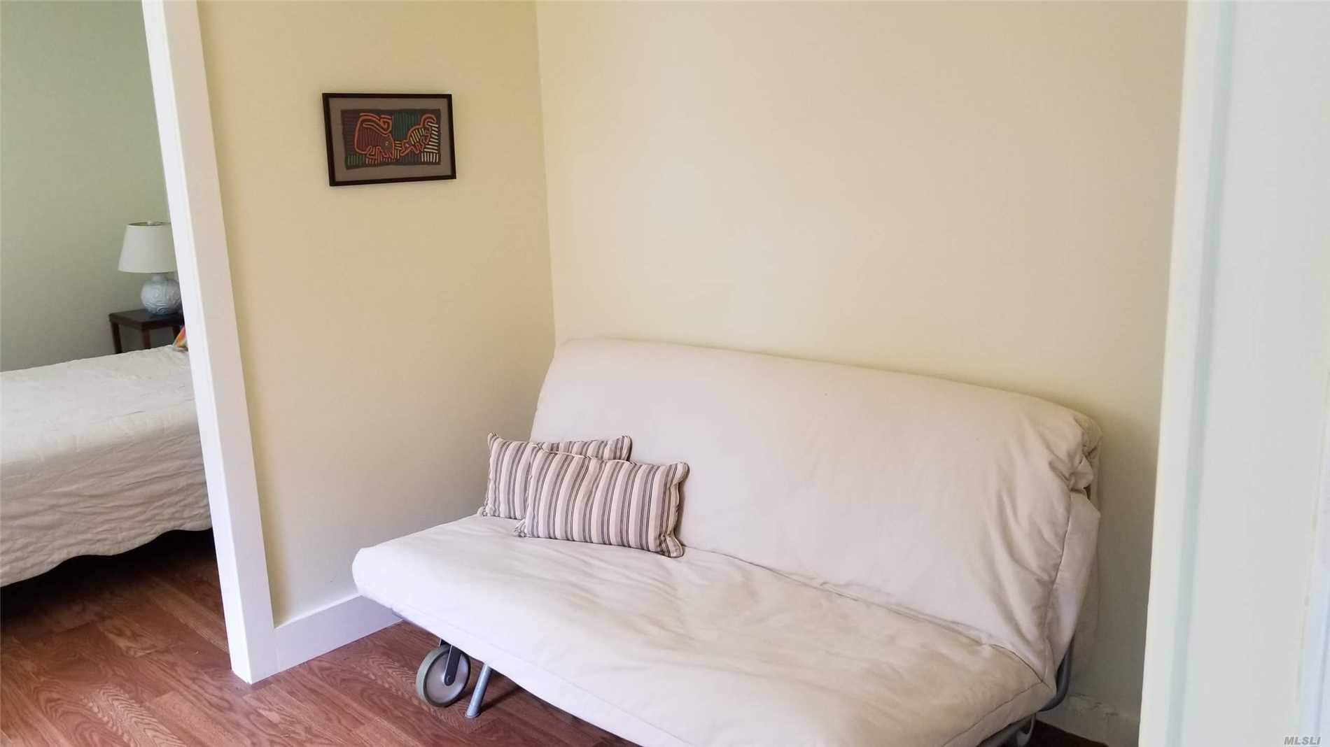 16640 Main Street, Unit COTTAG New Suffolk, NY 11956 - Photo 4 of 11 a bedroom with a bed and wooden floor