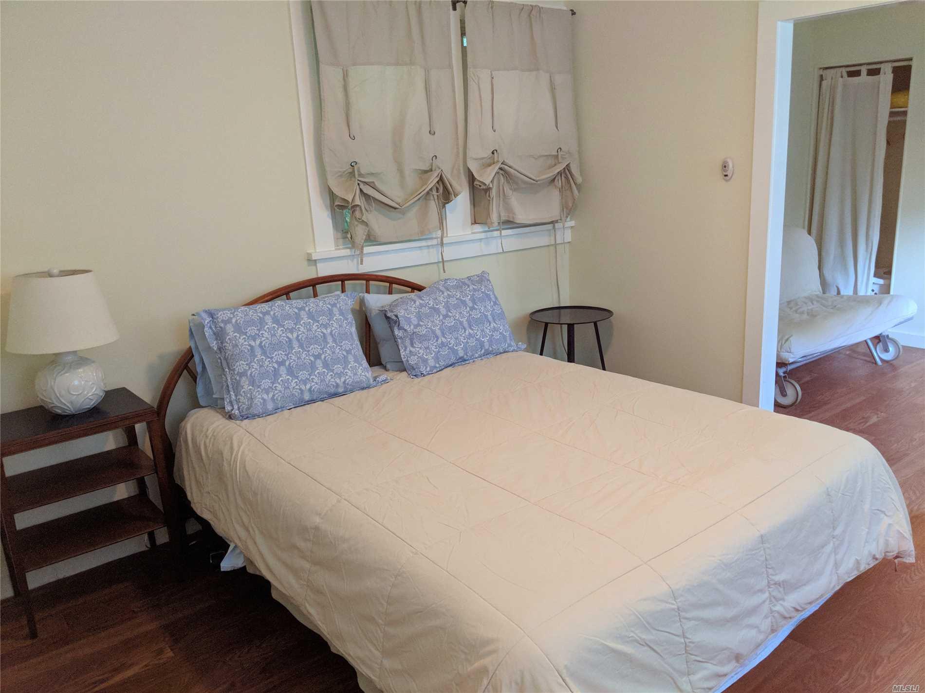 16640 Main Street, Unit COTTAG New Suffolk, NY 11956 - Photo 6 of 11 a bedroom with bed and wooden floor