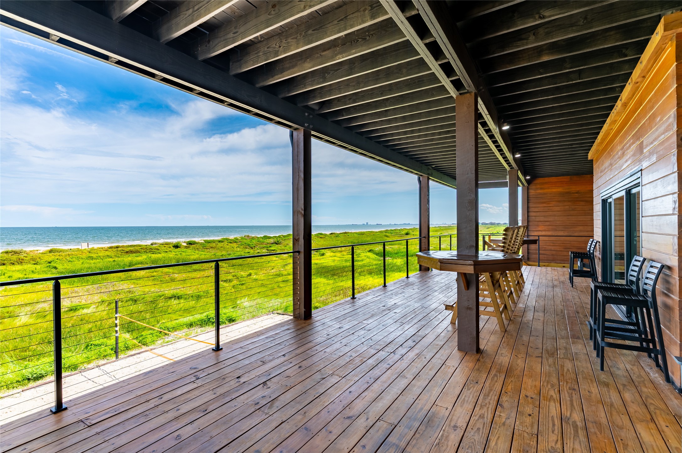 342 Atkinson Street Crystal Beach, TX 77650 - Photo 19 of 50 a deck with wooden floor table and chairs