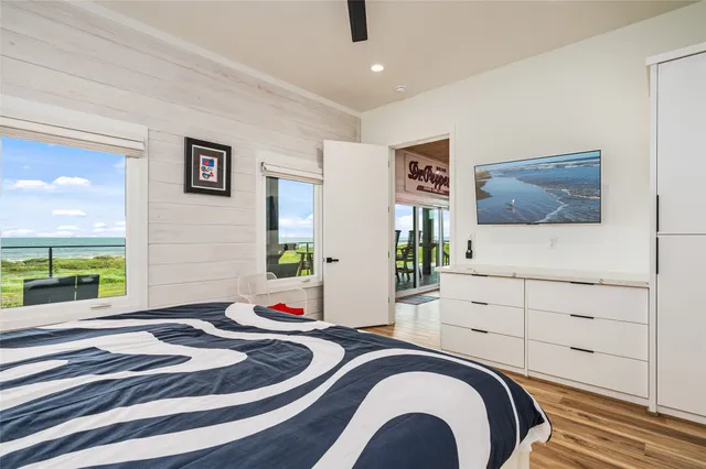 a bedroom with a bed and a flat tv screen on dresser