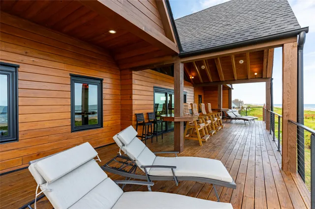 a view of a patio with dining table and chairs with wooden floor and fence