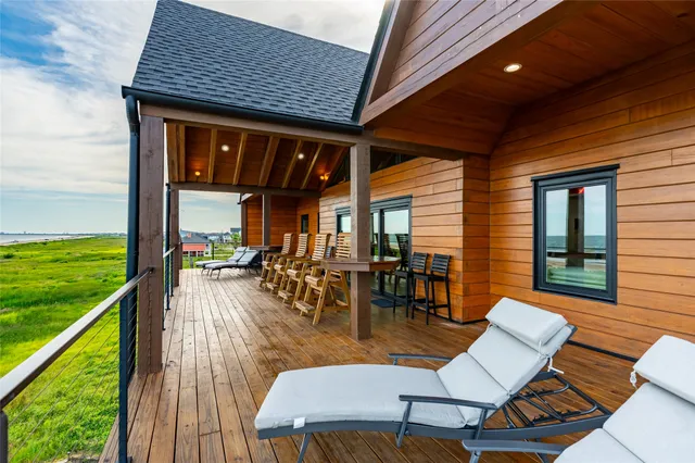 a view of a patio with table and chairs with wooden floor and fence