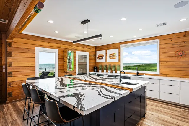 a dining hall with stainless steel appliances granite countertop a sink and a large window