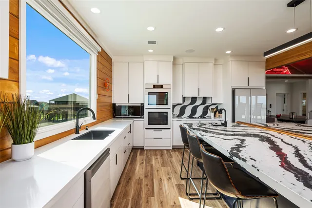 a kitchen with stainless steel appliances granite countertop sink microwave and wooden floor