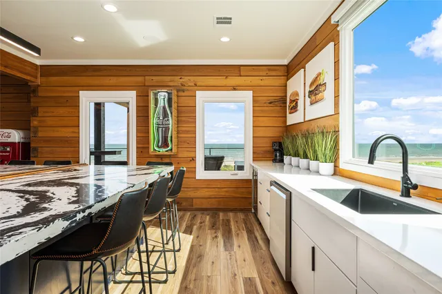 a large kitchen with kitchen island a stove a sink and cabinets
