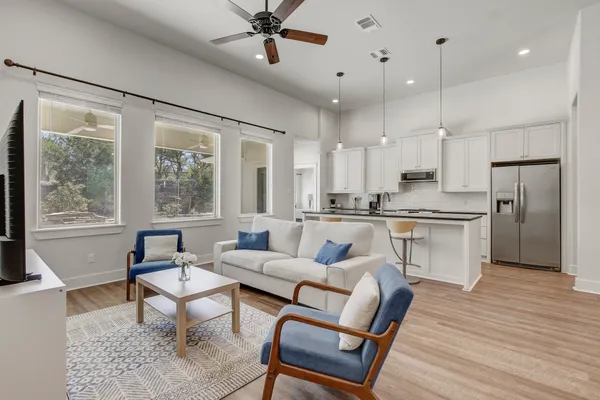 a living room with stainless steel appliances furniture and a large window