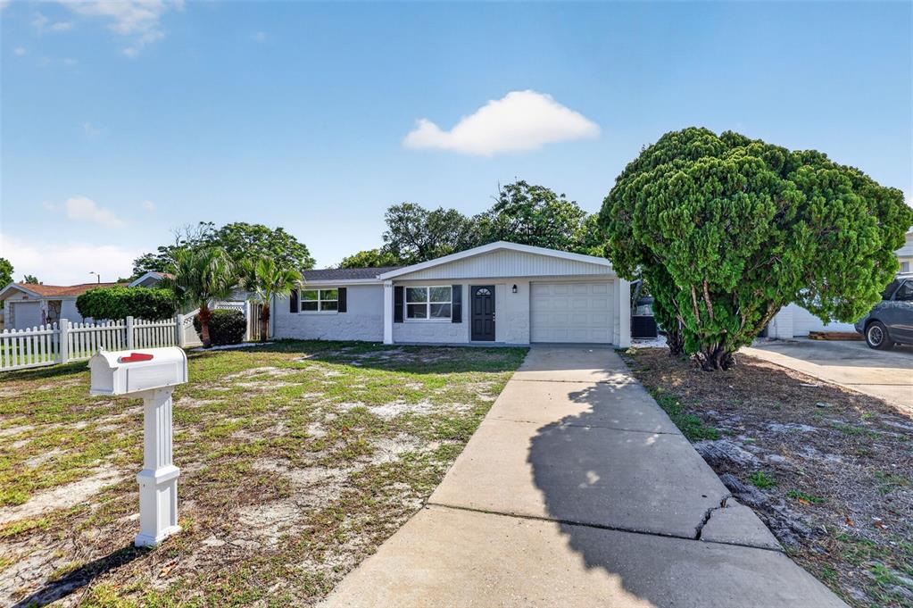 10914 Leeds Road Port Richey, FL 34668 - Photo 2 of 24 a front view of a house with garden