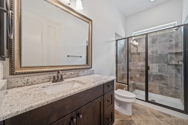 a bathroom with a granite countertop sink toilet and shower
