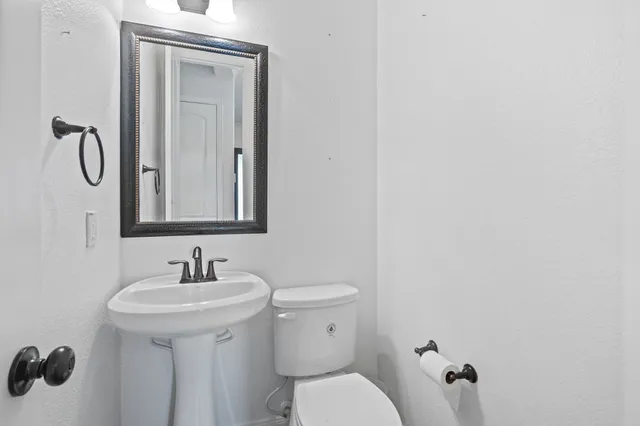 a bathroom with a toilet sink and mirror