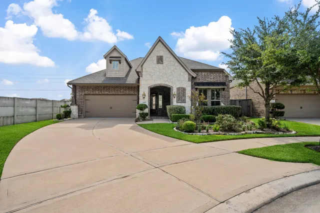 a front view of a house with a garden and trees