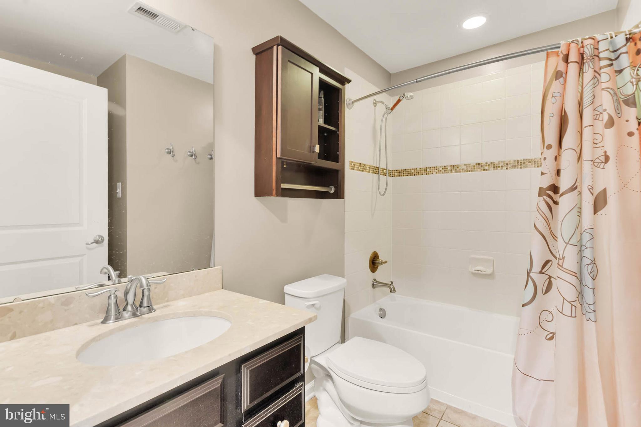 6367 Walcott Lane Frederick, MD 21703 - Photo 29 of 43 a bathroom with a granite countertop sink toilet a mirror a shower and a bathtub