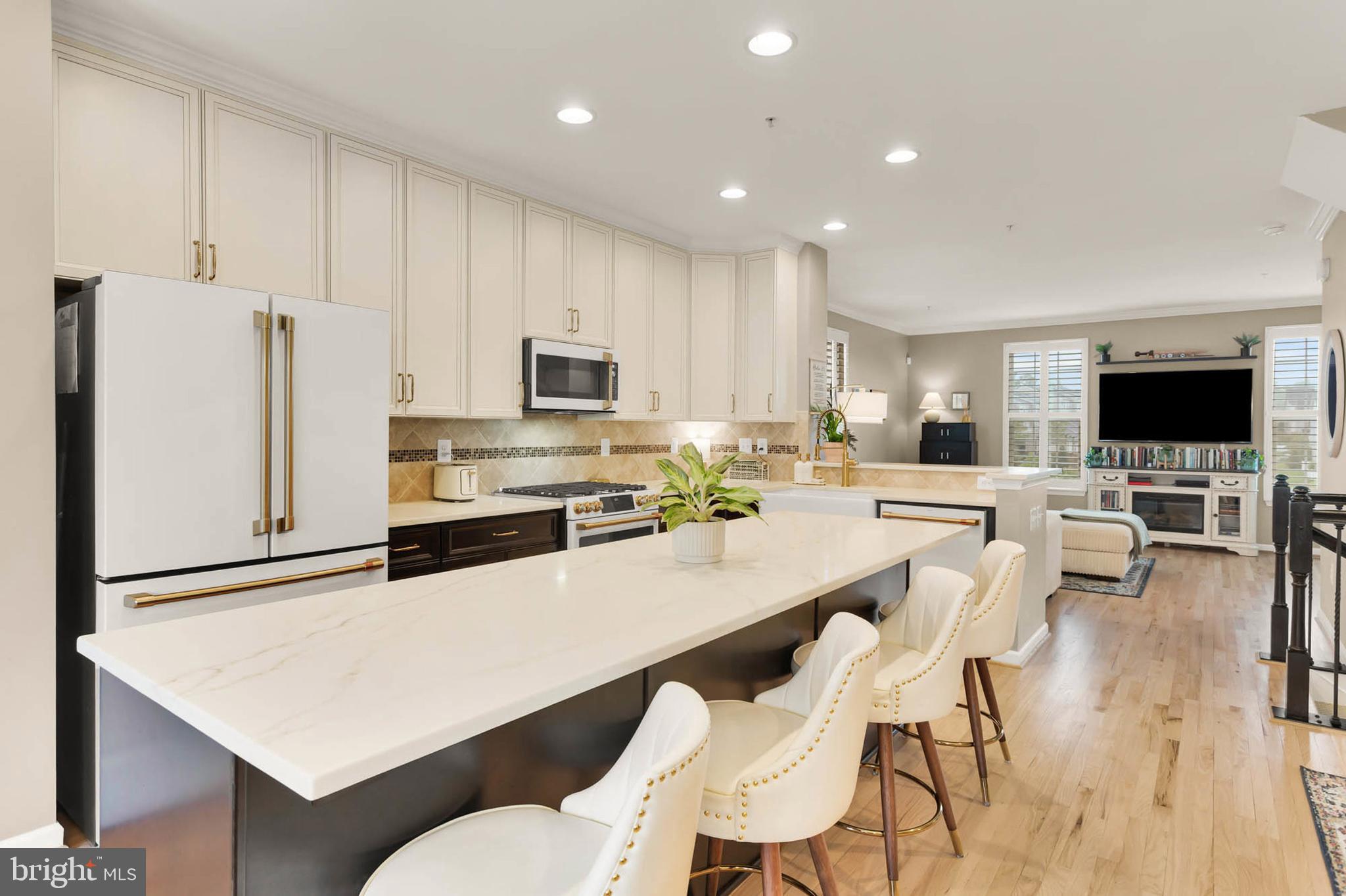 6367 Walcott Lane Frederick, MD 21703 - Photo 7 of 43 a kitchen with stainless steel appliances a refrigerator a stove a sink a dining table and chairs