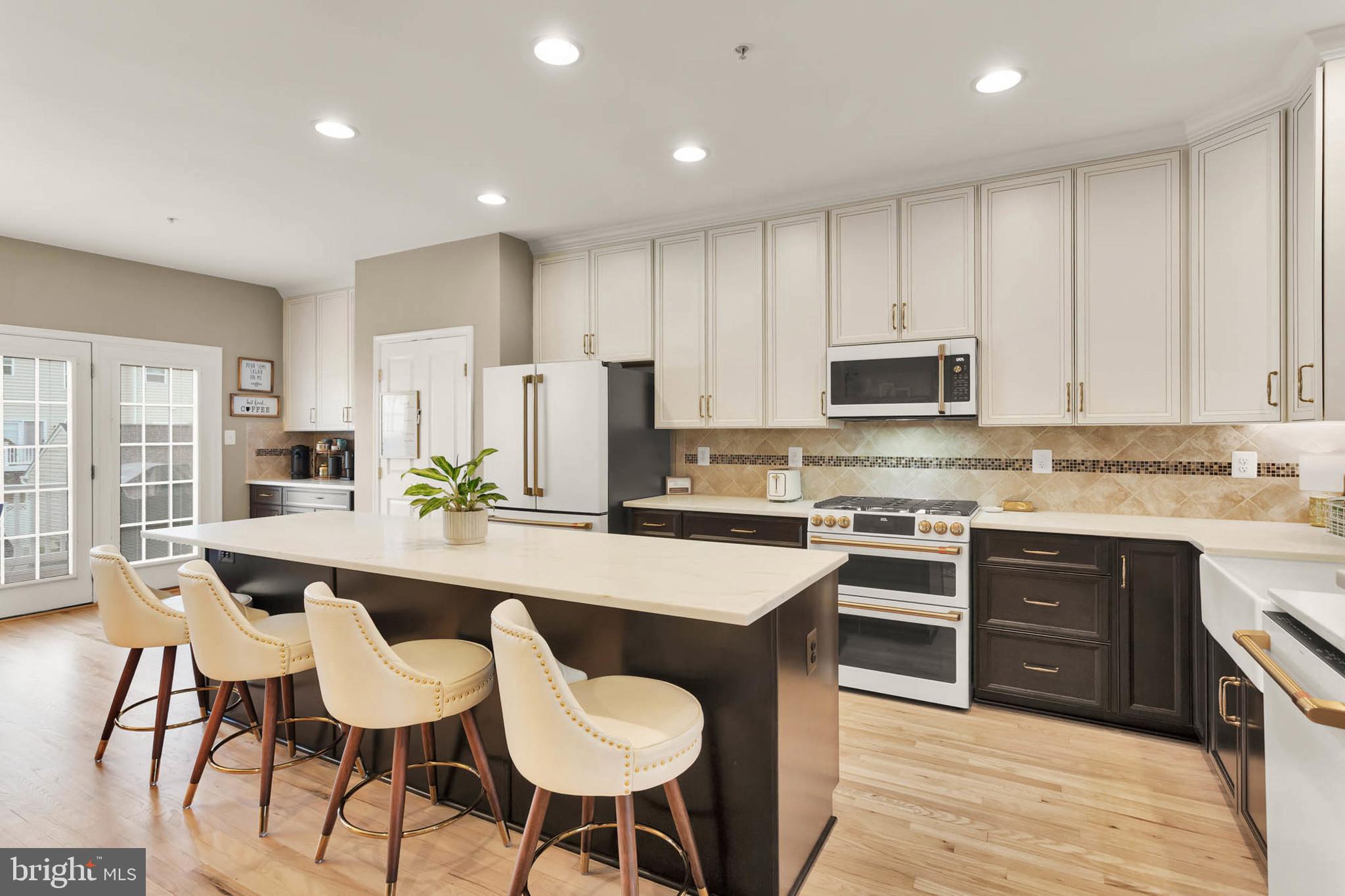 6367 Walcott Lane Frederick, MD 21703 - Photo 9 of 43 a large kitchen with stainless steel appliances granite countertop a stove a sink a refrigerator a dining table and chairs