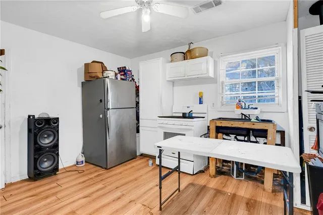 a kitchen with stainless steel appliances a dining table chairs and a refrigerator