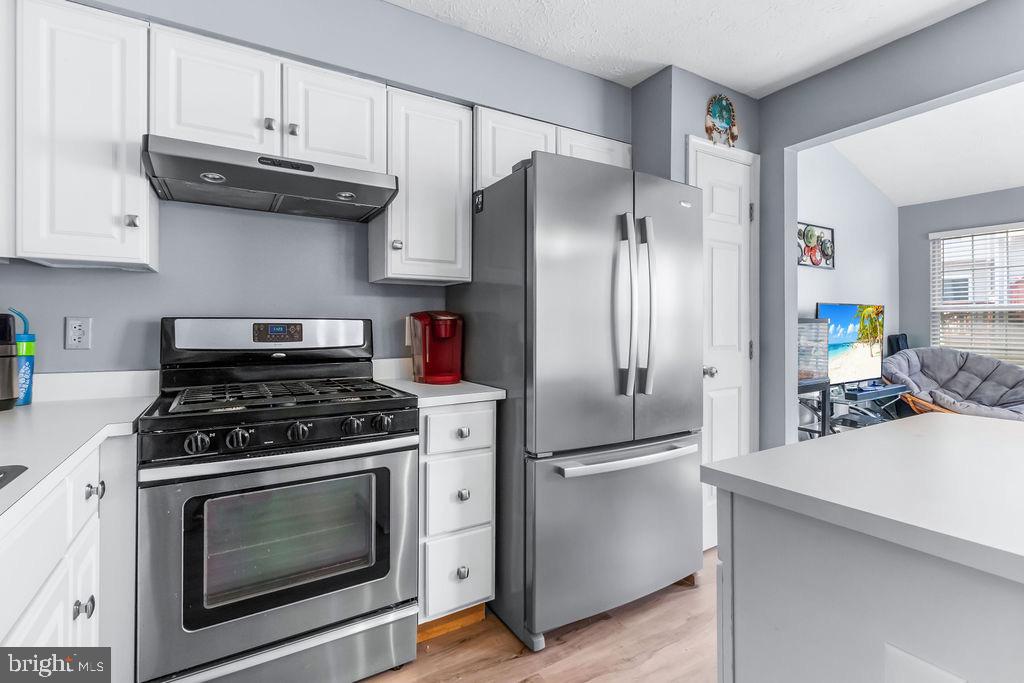 8605 Accokeek Street Laurel, MD 20724 - Photo 16 of 44 a kitchen with stainless steel appliances granite countertop a stove a refrigerator and a cabinets