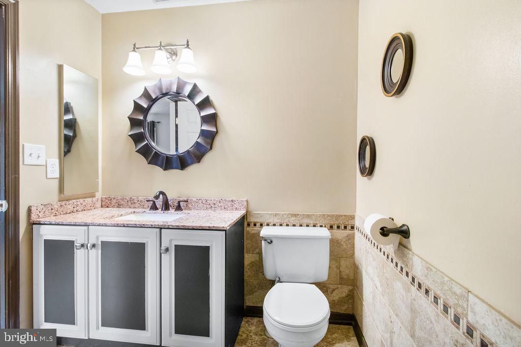 8605 Accokeek Street Laurel, MD 20724 - Photo 30 of 44 a bathroom with a toilet a sink and mirror