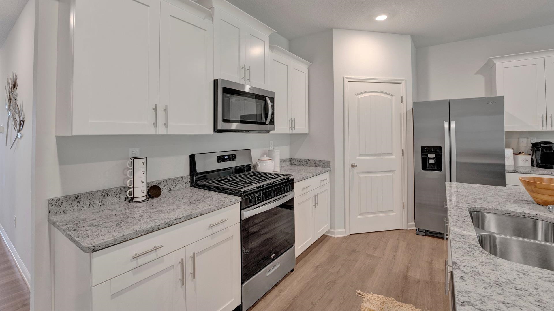 345 Windemere Loop Oakland, TN 38060 - Photo 5 of 23 a kitchen with granite countertop a sink stove and refrigerator